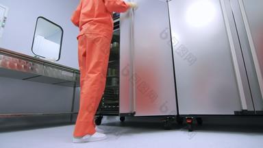 工厂工人橙色保护西装开放冰箱存储